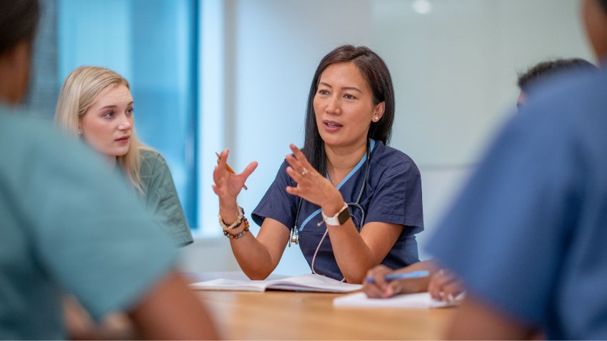 A doctor in a meeting with healthcare workers at boardroom