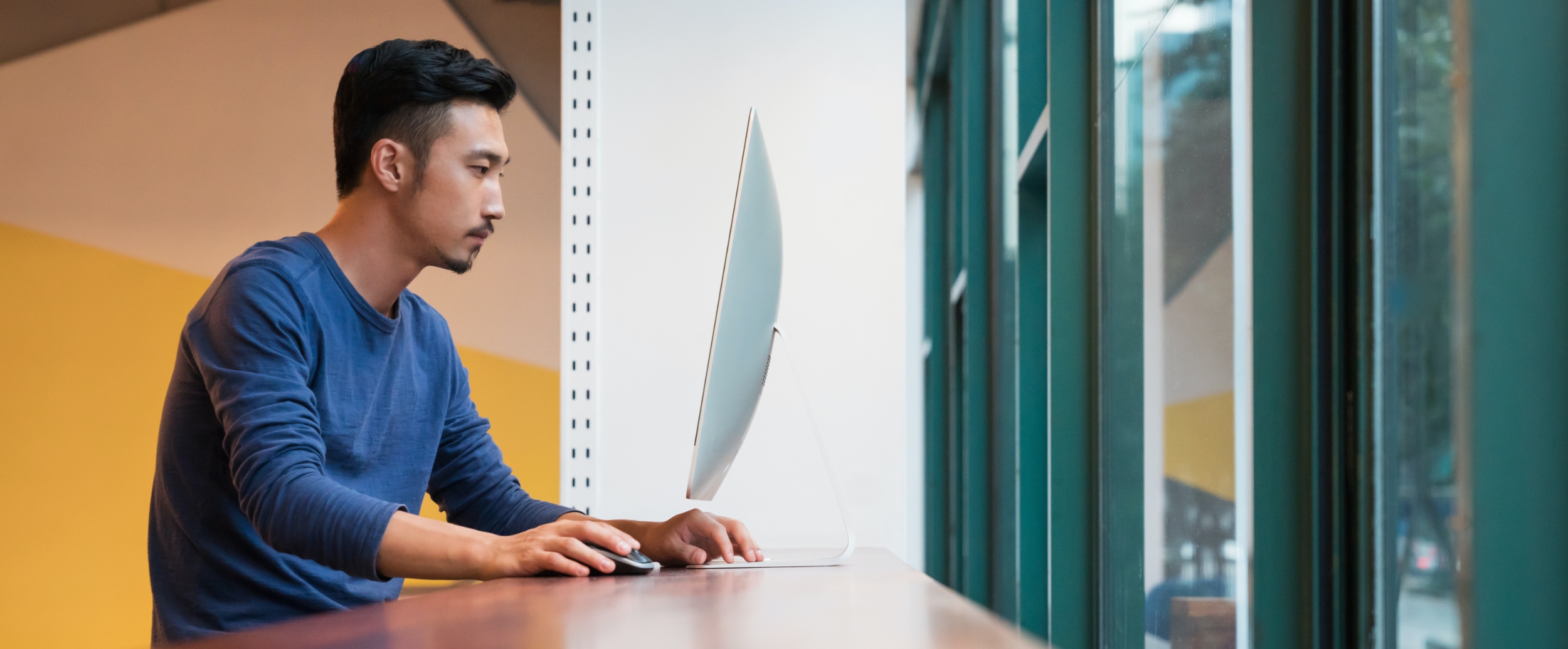 A young man working on a computer at workplace