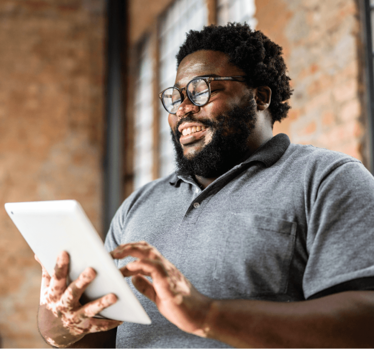 A man operating tablet with a smile on his face