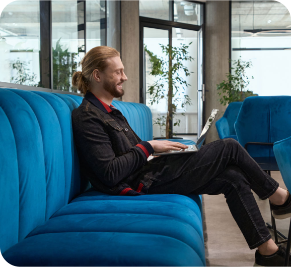 A gentleman working on a laptop while seating on a sofa