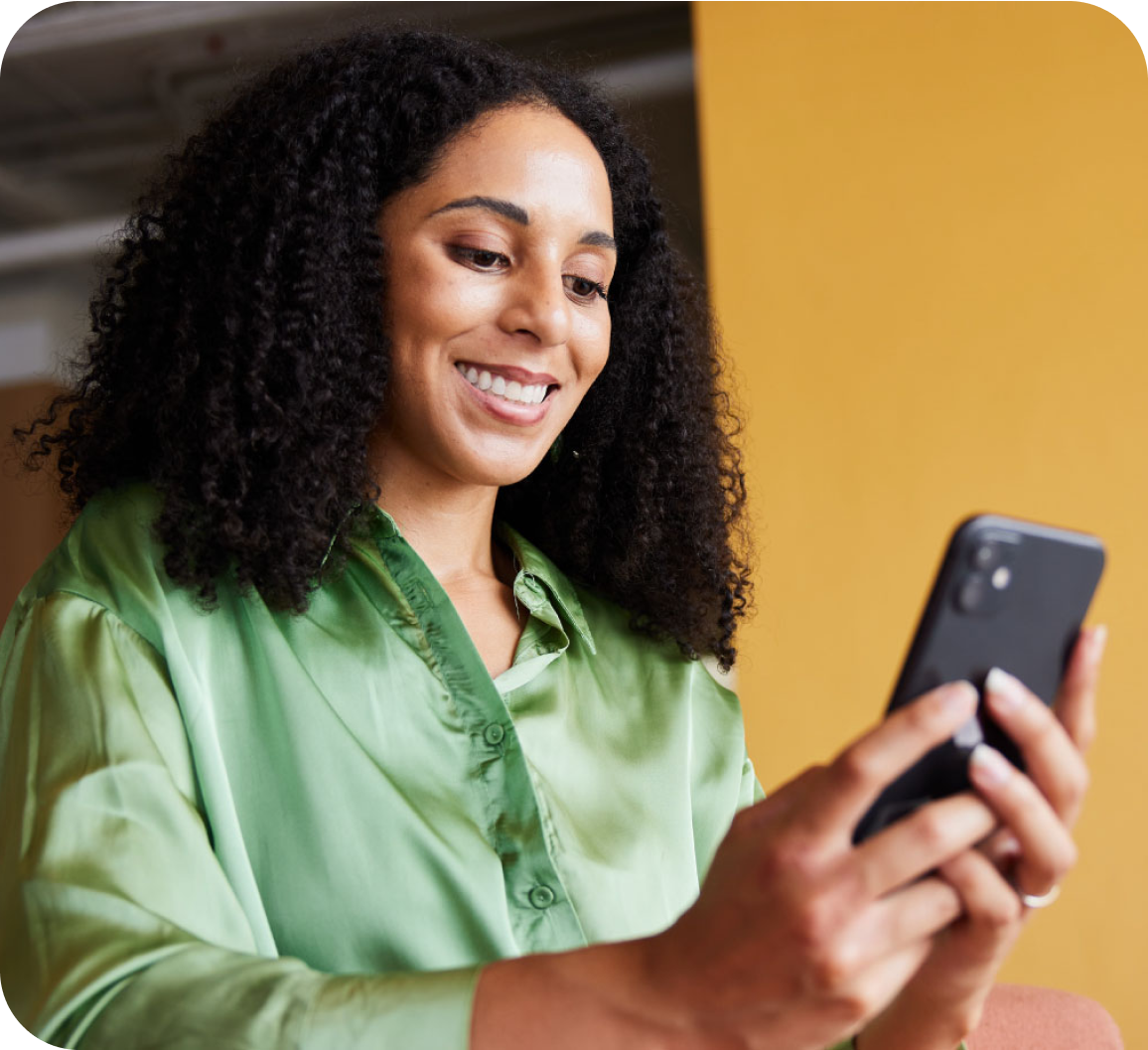 A woman looking at phone screen with a smile