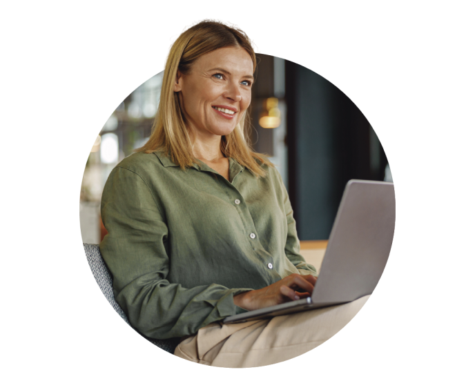 A woman with a smile working on a laptop