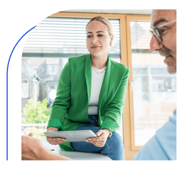 Two office employees in a discussion while looking at tablet screen