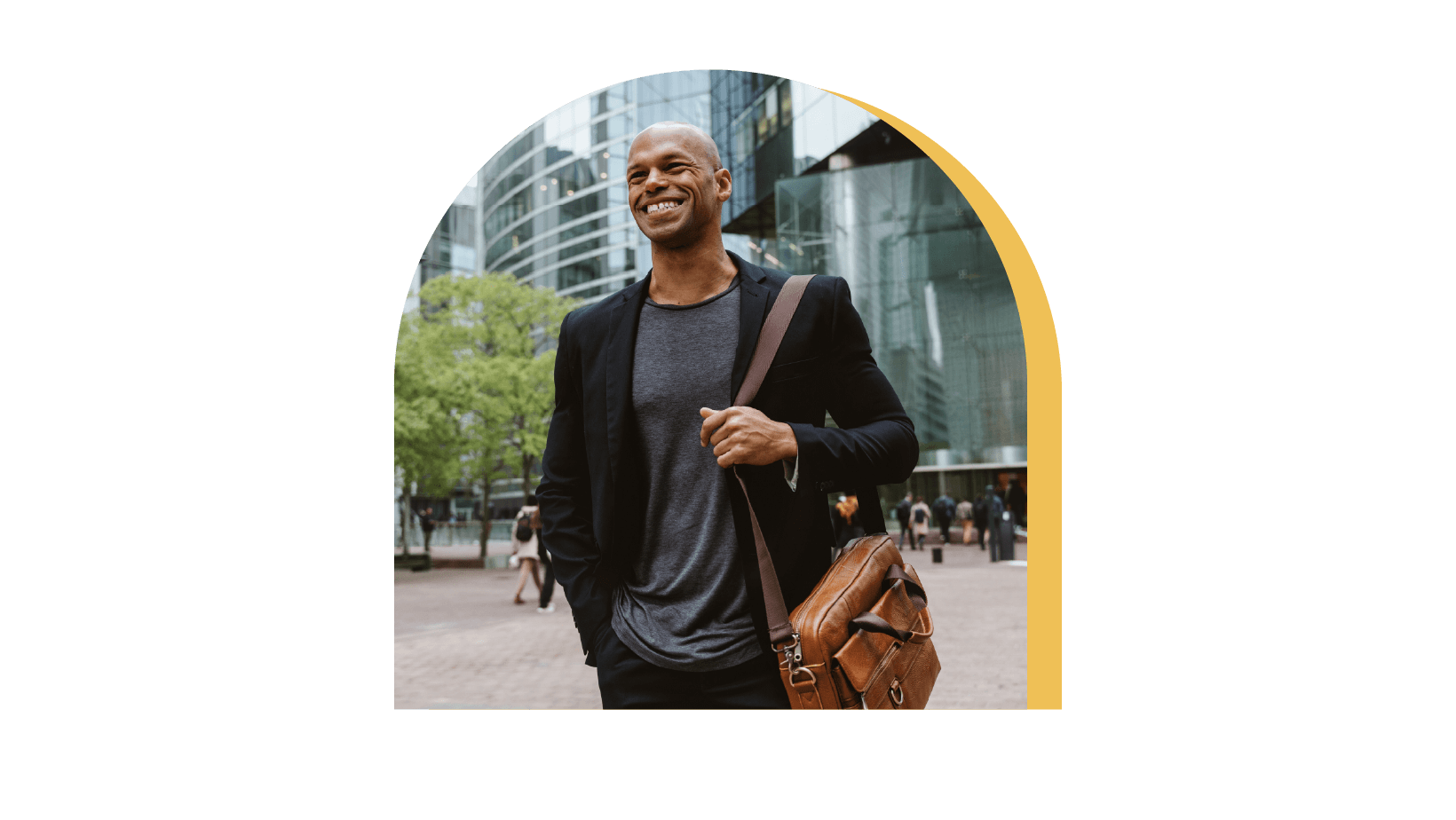 A gentleman in a black blazer walking down the business park with a smile