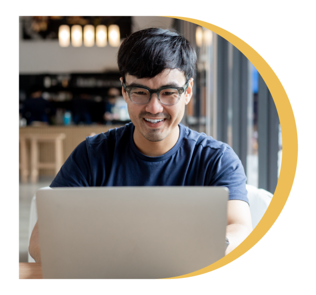 A picture of man in blue t-shirt using laptop