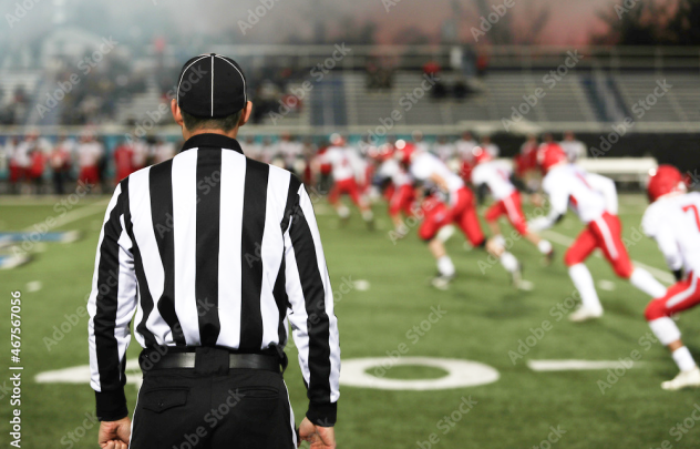 A Football referee and football players on the field